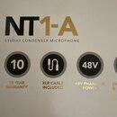 Fotografie detailu krabice od mikrofonu. Je na ní uveden název modelu NT1-A a nápis STUDIO CONDENSER MICROPHONE. Pod tím jsou tři ikony s texty 10 YE…