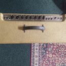Kytarový kombozesilovač s béžovým potahem z textilie. Na předním ovládacím panelu jsou nápisy INPUT, VOLUME, DRIVE, TREBLE, BASS, MIDDLE, REVERB a PR…
