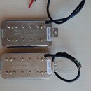 Dva elektrické snímače typu humbucker v kovovém stříbrném krytí. Horní snímač nese nápis „Seymour Duncan. Made in America“ a bílou nálepu s textem „1…