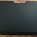 Černý, plochý hudební pult s vyhlubení v horní části. V pravém horním rohu je oranžový nápis SLI MAGNETIC MUSIC STAND. Povrch vykazuje mírné známky o…