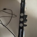 Černý DJ kontrolér s bílým nápisem Numark na boku. Na horní části je vidět označení PARTY MIX a dva výstupy s nápisem MASTER. Boční strana obsahuje t…