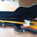 Elektrická kytara s polodupatým korpusem v barevném přechodu od žluté přes oranžovou k červené a černé. Nástroj má bílý pickguard, dva trsací snímače…