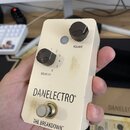 Kompaktní efekt pedál v krémové barvě s dvěma černými ovládacími knoflíky. Na pedálu jsou nápisy VOLUME, BREAK-UP a v dolní části značka DANELECTRO®…