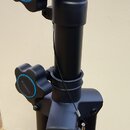 Černý kovový stojan s dvěma plastovými utahovacími knoflíky modrým kruhem. Na knoflících i na spodní části stojanu je bílý nápis VONYX. Povrch je mat…