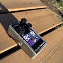Kytarový efekt v kovovém stříbrném šasi s fialovým panelem. Na panelu je bílý nápis BASS CLONE a v dolní části logo electro-harmonix. Zařízení má čty…