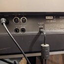 Záběr na zadní panel černého klavírního nástroje. Je zde vidět logo KORG a nápis MODEL SP-250, Designed in Italy, Made in China. Panel obsahuje konek…