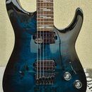Elektrická kytara s modře stínovaným povrchem z plamenového javoru a černými okraji. Nástroj má dva humbuckery s tmavě červenými cívkami, černý most…