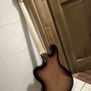 Fotografie zachycuje zadní stranu elektrické kytary s tmelelovým povrchem v přechodu od hnědé k černé barvě (sunburst). Krk je vyroben ze světlého dř…