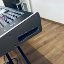 Detailní pohled na zadní část šedého elektronického zařízení s kovovým povrchem. Jsou vidět tři konektory s popisky SD CARD, HDMI a USB. V horní část…
