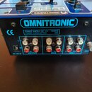 Zadní strana modrého DJ mixeru značky OMNITRONIC. Na zadním panelu jsou vidět tři dvojice RCA konektorů s popisky OUTPUT, CH-2 a CH-1, vstup AC 10V I…