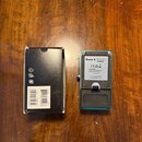 Na fotografii je modrý efekt pedál a černá kartonová krabice. Na zadní straně pedálu je nápis Ibanez, POWER SOURCE DC 9V adapter a označení MADE IN J…