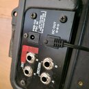 Detail zadní strany černého elektronického zařízení s několika konektory. Na panelu jsou bílé nápisy PSB-1U/ PSC IN, USE ROLAND PSB-1U OR BOSS PSC AD…
