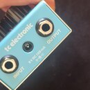 Modře lakovaný efekt pedál s nápisem tc electronic. Na spodní hraně jsou dva kovové konektory označené jako INPUT a OUTPUT a uprostřed vstup pro napá…