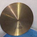 Kruhová mosazná činely s viditelným broušením povrchu. Ve spodní části je nápis PAiste a nad středovým otvorem označení 18". Mezi nimi se nachází dro…