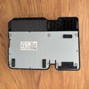 Zadní strana černého elektronického zařízení s šedým kovovým krytem. Na bílém štítku je uveden nápis ZOOM, ZOOM CORPORATION, Design by ZOOM in Japan,…