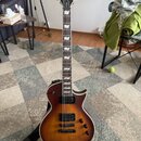 Elektrická kytara s trupem v hnědém sunburst provedení a viditnou strukturou dřeva. Na hlavě je bílé logo LTD a nápis Deluxe, na hmatníku jsou bílé v…