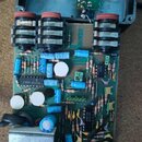 Fotografie znázorňuje otevřený elektronický přístroj s plošným spojem a třemi černými otočnými potenciometry s červenými knoflíky. Na desce jsou vidě…