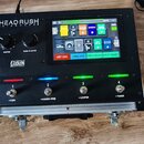 Černý kontrolér HeadRush Go Board umístěný v hliníkovém kufru. Na horním panelu jsou čtyři kovové přepínače s označením -VIEW, -HANDS-FREE, -LOOPER a…