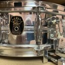 Stříbrný kovový snare drum s chromovaným povrchem. Na korpusu je černý štít s nápisy ROMAL Star, FINEST QUALITY a JAPAN. Povrch vykazuje drobné škráb…