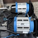 Dva modré studiové reflektory s hliníkovým chladičem a černými klapkami. Na štítku předního přístroje je uveden nápis ARRI, model ARRI 650, Serial Nu…