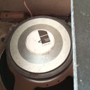 Fotografie zachycuje zadní část reproduktoru s kovovým magnetem. Uprostřed je bílá nálepka s logem CELESTION a nápisy Celestion Ipswich England oraz…