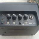 Černý kompaktní kytarový zesilovač značky NUX, model MIGHTY LITE BT. Na horní ovládací ploše jsou čtyři otočné knoflíky s popisky OD/DIST, DRUM, REVE…