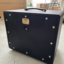 Černý kytarový reproduktor v texturovaném obalu s rukojetí nahoře. Na zadní straně je kovový štítek s nápisy „FRIEDMAN 112“, „1x12" Cabinet Cab“, „Ha…