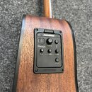 Detailní pohled na předzápisovou elektroniku v těle akustické kytary s dřevěným povrchem. Černý ovládací panel nese nápisy FISHMAN, Presys, volume, b…