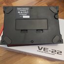 Fotografie zachycuje spodní stranu černého elektronického zařízení. Na bílém štítku je uveden nápis Roland Corporation, země výroby MADE IN MALAYSIA…