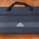 Černý obdélníkový softcase z textilie s rukojetí a zipem. Uprostřed je bílý nápis „ROY BENSON WIND INSTRUMENTS“ s malou korunkou nad textem. Povrch j…