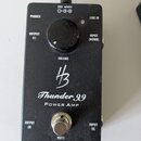 Černý výkonový zesilovač v kovovém boxu s nápisy Thunder 99 a POWER AMP. Uprostřed je logo HB a ovratový knoflík s popiskem VOLUME. Zařízení má vstup…