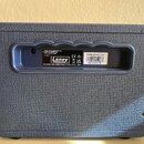 Zadní strana modrého kytarového komba s texturovaným povrchem. V prohlubni je umístěn černý štítek s bílým logem Laney a nápisy MADE IN CHINA FABRIQU…