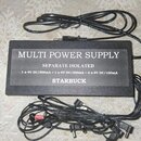 Černý napájecí adaptér s nápisy MULTI POWER SUPPLY, SEPARATE ISOLATED a STARBUCK. Pod nápisem Separate Isolated je uvedena specifikace 1 x 9V DC/500m…