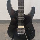 Černá elektrická kytara s tmavým hmatníkem a dvěma humbuckery. Kobylka je chromovaná, s mechanismem pro tremolo. Na těle jsou dva ovládací knofíky a…