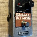 Stříbrný efekt pedál v kovovém pouzdře s černým ovládacím panelem. Na panelu je nápis SMALL STONE, pod ním EH4800 PHASE SHIFTER a v dolní části logo…