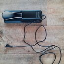 Černý elektronický pedál s kovovým stříbrným šlapadlem. Na boku je bílý nápis „cherub“ a pod ním označení modelu „MODEL: CLV-100“. Zařízení má připoj…