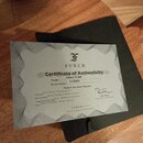 Fotografie zobrazuje papírový Certificate of Authenticity značky FURCH, který leží na černém obalu. Dokument obsahuje text „Violet D-SM“, model „1135…