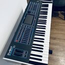 Klávesový syntezátor s černým ovládacím panelem a bílými klávesami. Na levé straně je nápis EVENT 61 a pod ním menší text BEATMAKER. Přístroj obsahuj…