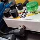 Bílý efekt pedál s pěti ovládacími knoflíky, z nichž jeden je výrazně větší a zelený. Na horní části je nápis electro-harmonix NEW YORK CITY, USA a č…