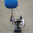Fotografie znázorňuje mechanické příslušenství z černého kovu s modrým pěnovým krytem na horním konci kovové tyče. Zařízení obsahuje pružiny, šrouby…