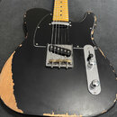Černá elektrická kytara typu Telecaster s černým pickguardem a hmatníkem z jasného dřeva. Na těle jsou vidět výrazné oděry a chybějící laky, zejména…