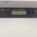 Černý rackový efektový procesor s digitálním displejem a ovládacími tlačítky. Na předním panelu je bílý nápis YAMAHA PROFESSIONAL MULTI-EFFECT PROCES…
