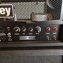 Detail kytarového komba s černým předním panelem a mřížkou. Na panelu je bílý nápis IRONHEART a ovládací prvky s popisky TREBLE, LEAD VOLUME, RHYTHM…