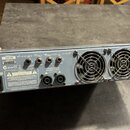 Zadní strana stříbrného zesilovače s nápisem Ashdown Bass Magnifier EVOI V. Na štítku je uveden MODEL #: ABM-600 a SERIAL #: 204025, vedle jsou loga…