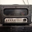 Zadní strana černého kytarového komba s texturovaným povrchem a kovovou ventilační mřížkou. Na spodním panelu je nápis LITTLE GIANT 5 - SINGLE ENDED/…