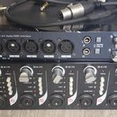 Fotografie zobrazuje dvě rackové jednotky umístěné nad sebou a několik kabelů. Horní zařízení je černý audio rozhraní s nápisem TASCAM US-1641 16x4 9…
