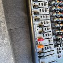Detailní pohled na část míchacího pultu s posuvníky a ovládacími knoflíky. Na levém okrave jsou vidět označení kanálů 3, 4, 5, 6, 7/8, 9/10, 11/12, 1…