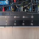 Černý efektový switching systém s nápisy BOSS EFFECTS SWITCHING SYSTEM ES-8. Zařízení má digitální displej, ovládací tlačítka a osm kovových spínačů…