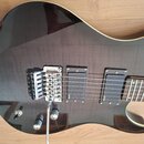 Tělo elektrické kytary v tmavě vínové barvě s viditelnou strukturou dřeva. Nástroj je vybaven stříbrným tremolo mostem a dvěma černými humbuckery s n…