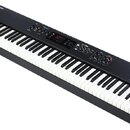 Černý digitální klavír s dřevěnými bočními panely. Na levém horním rohu je logo studiologic a vpravo dole nápis numaxpiano. Horní panel obsahuje ovlá…